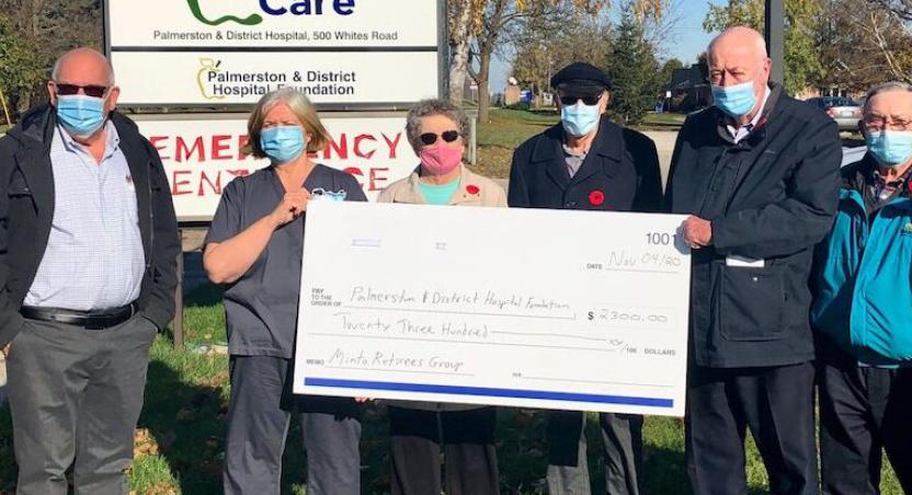 group of people presenting large cheque